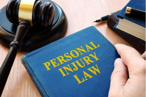 Personal injury law book and judge gavel concept of liability