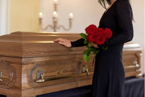 Mableton wrongful death lawyer concept young woman touching casket at funeral