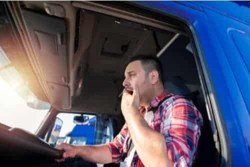 Tired truck driver yawning while driving