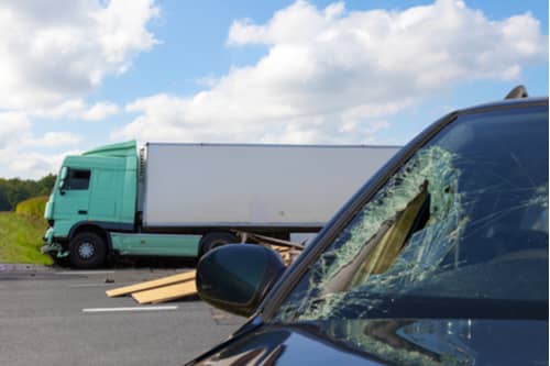 Truck accident in Atlanta Georgia involving a semi and a black sedan with a broken windshield